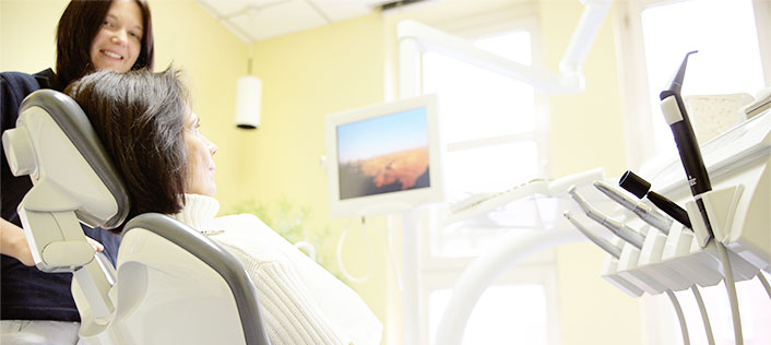Bild lächelnde Zahnarzt-Assistentin in hellen Behandlungsraum -  Service, Beratung und Terminvereinbarung in Zahnarztpraxis Dr. Weitze Hamburg